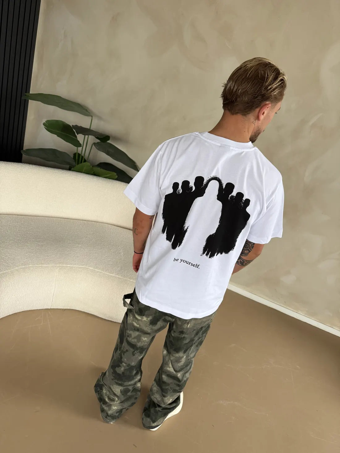 A man in a white shirt, seen from behind.